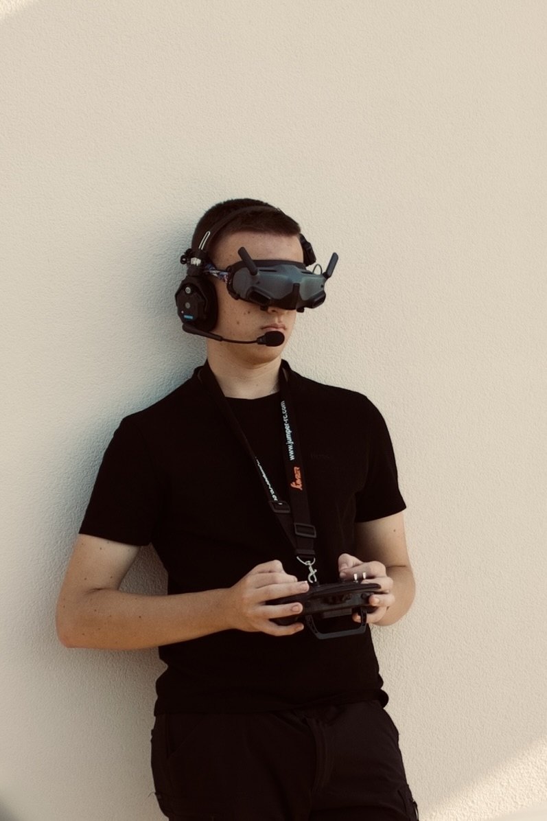 Michael flying an FPV drone, wearing video goggles and holding the controller